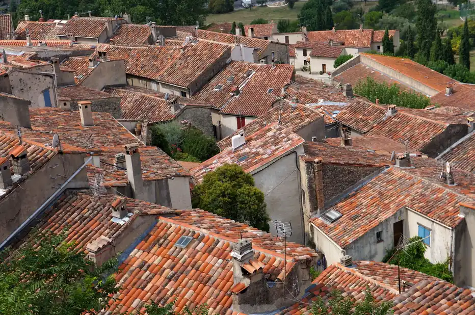 Toitures de tuiles serrées d'un village vues depuis les hauteurs