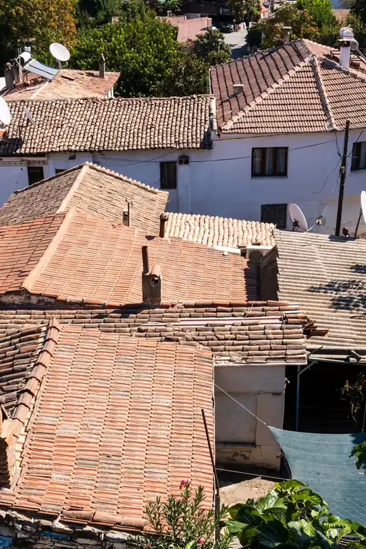 Maisons blanches et toitures de tuiles étagées sur un versant