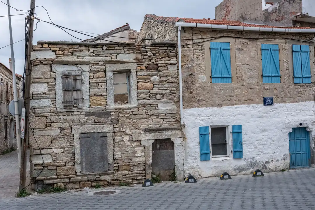 Maison de pierre à volets bleus couverte en tuile canal
